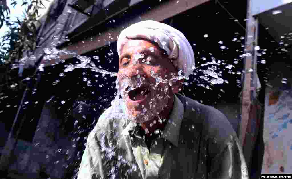 Житель пакистанского города Карачи умывает лицо водой во Всемирный день воды