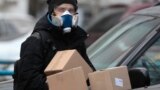 RUSSIA PANDEMIC CORONAVIRUS COVID19 -- A courier wearing a respirator carries boxes from an online shop in Moscow, Russia, 03 April 2020.