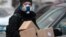 RUSSIA PANDEMIC CORONAVIRUS COVID19 -- A courier wearing a respirator carries boxes from an online shop in Moscow, Russia, 03 April 2020.