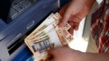 Belarus -- A man withdraws cash from ATM machine on the first day of the redenomination of the Belarusian ruble, in Minsk, July 1, 2016