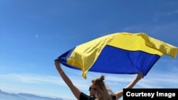 Наталья с украинским флагом, который она повсюду возит с собой. Везувий, Италия, весна 2024 года