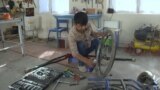 Tajikistan -- a man repairs a wheel cheer