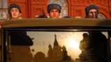 RUSSIA -- Russian soldiers dressed in Red Army World War II uniforms sit in the back of a truck as the St. Basil's Cathedral is reflected in the windshield prior to the start of the Nov. 7 parade in Red Square, with St. Basil Cathedral and thew Spasskaya 