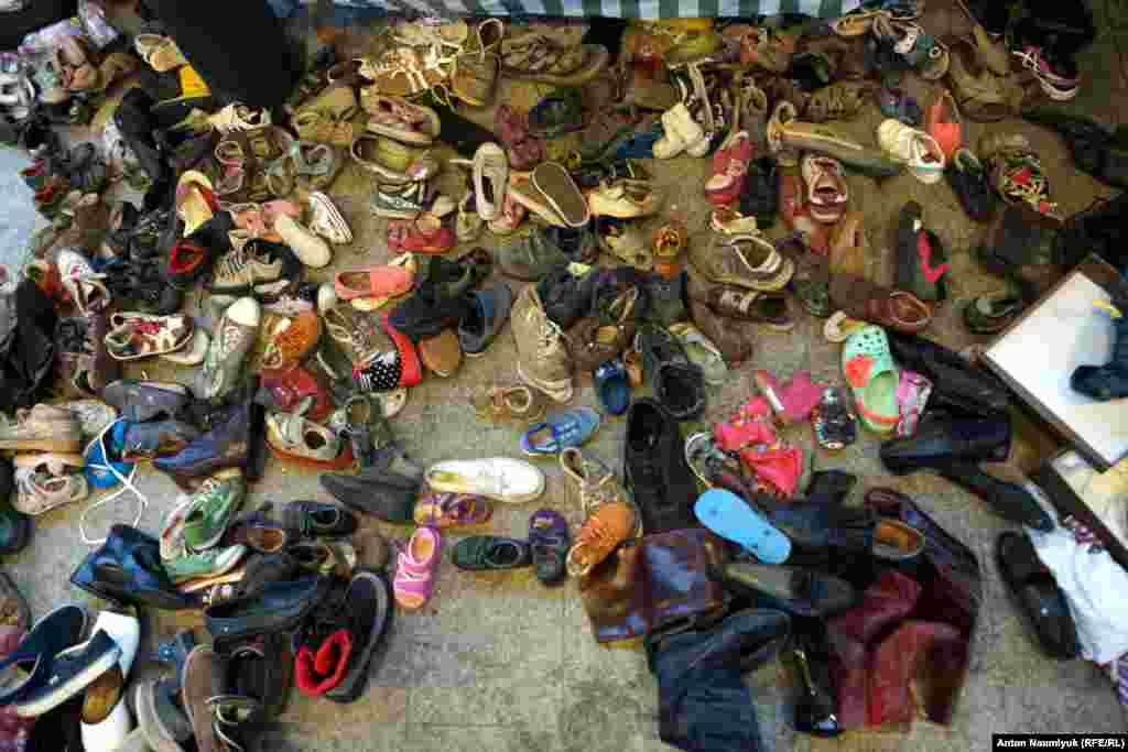 Обувь свалена на полу в кучу, из которой ее может взять любой желающий