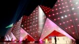 Azerbaijan - A woman stands in front of the illuminated building of Crystal Hall in Baku, Azerbaijan 25 June 2015. The Baku 2015 European Games will run until 28 June