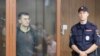 RUSSIA -- Participant of a recent rally to demand free elections Yevgeny Kovalenko stands inside a defendants' cage during a court hearing in Moscow, Russia September 4, 2019.