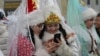 Kyrgyzstan -- Women dressed as Snegurochka (Snow Maiden) look at a mobile phone during New Year's parade in the Kyrgyz capital Bishkek on December 31, 2015.