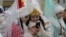 Kyrgyzstan -- Women dressed as Snegurochka (Snow Maiden) look at a mobile phone during New Year's parade in the Kyrgyz capital Bishkek on December 31, 2015.