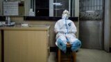 A medical worker in protective suit takes a break during her night shift at a community health service center, which has an isolated section to receive patients with mild symptoms caused by the novel coronavirus and suspected patients of the virus, in Qin