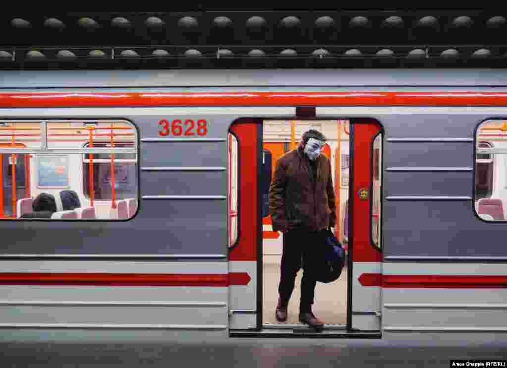 Мужчина в маске Гая Фокса на выходе из вагона метро. Власти Праги 17 марта объявили, что пассажиры общественного транспорта обязаны носить маски. Мэр Праги написал в Тwitter&#39;е, что жители должны закрывать рот и нос в транспорте: &quot;Неважно, будут ли медицинские маски, маски собственного изготовления или шарф, это лучше, чем ничего&quot;.&nbsp;