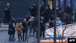 Полиция выводит людей из магазина,в котором были захвачены заложники