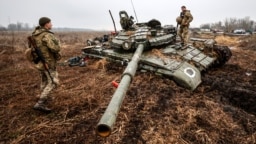 Украинские военные у подбитого под Черниговом российского танка