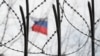 UKRAINE – A Russian flag is seen behind a barbwire on a fence of the Russian Embassy in Kyiv, 21 February 2022