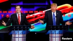 Бывший кандидат в президенты от республиканцев Марко Рубио и его соперник Дональд Трамп во время дебатов