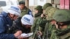 UKRAINE -- OSCE Special Monitoring Mission officials note down serial numbers of rifles as Russia-backed separatist fighters withdraw from the town of Zolote in the eastern Luhansk region, October 29, 2019