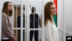 Журналистки Дарья Чульцова (слева) и Катерина Андреева в клетке для обвиняемых в зале суда в Минске, Беларусь, 18 февраля 2021 года
