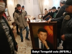 Protesters in Bishkek's White House with a portrait of President Sooronbai Jeenbekov