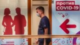 RUSSIA -- A man wearing a face mask walks past the vaccination point at the State Department Store GUM in Moscow, June 15, 2021