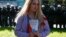 RUSSIA -- A woman holds a booklet, containing the Constitution of Russia, while posing for a picture in front of servicemen of the Russian National Guard during a rally against pension reforms, which envisage raising the retirement age of citizens, in St.