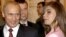 Russia -- President Vladimir Putin (L) smiles next to Russian gymnast Alina Kabayeva during the meeting with the Russian Olympic team in Moscow's Kremlin, November 4, 2004