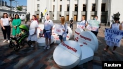 Пациенты и активисты принимают участие в перформансе с требованием декриминализации медицинского каннабиса перед зданием Рады в Киеве, Украина, 13 июля 2021 года 