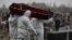 RUSSIA -- Grave diggers wearing personal protective equipment (PPE) carry the coffin of a person, who presumably died of the coronavirus disease (COVID-19), during a funeral at a cemetery in Omsk, November 3, 2020