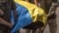 Ukrainian soldiers carry a coffin, covered with the national flag, of a Ukrainian serviceman Yurii Yurchenko, who was killed fighting Russian troops in the Lugansk region, during the funeral service at the Saint Michael's Golden-Domed Monastery in Kyiv, o