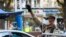 UZBEKISTAN -- A serviceman raises his hand as a traffic policeman checks the ID of a driver at a checkpoint amid the ongoing coronavirus disease pandemic in Tashkent, July 23, 2020