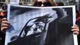 KYRGYZSTAN -- A woman holds a picture as she attends a rally for women's rights protection in Bishkek, April 8, 2021