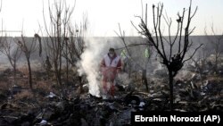  Rescue workers search the scene where an Ukrainian plane crashed in Shahedshahr, southwest of Iran's capital, Tehran, on January 8, 2020. 