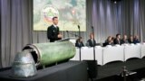 NETHERLANDS -- Dutch police officer Wilbert Paulissen, head of the National Crime Squad, is pictured next to a damaged missile as he presents interim results in the ongoing investigation of the 2014 MH17 crash that killed 298 people over eastern Ukraine, 