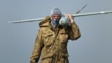 Ukraine - A Ukrainian soldier carries a surveillance drone near Mariupol. screen grab