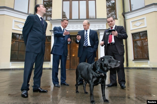 Старое здание резиденции в Ново-Огарёве. На фото чиновники и конструкторы стоят вокруг вокруг собаки Кони с устройством ГЛОНАСС-GPS в ошейнике. 17 октября 2008 года