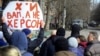 Протестующие против оккупации жители Херсона стоят перед колонной российских военных, март 2022 года. Фото: AP