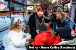 Виталия (слева) участвует в рождественских поздравлениях пассажиров трамвая