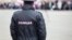 Russian policeman officer stands to opposite crowd with inscription Police on the uniform jacket, Russia, copy space