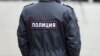 Russian policeman officer stands to opposite crowd with inscription Police on the uniform jacket, Russia, copy space