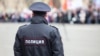 Russian policeman officer stands to opposite crowd with inscription Police on the uniform jacket, Russia, copy space