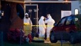 Работники ФБР в костюмах химической защиты осматривают дом после серии рициновых отравлений