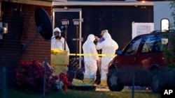 Работники ФБР в костюмах химической защиты осматривают дом после серии рициновых отравлений