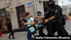 Law enforcement officers are shown detaining journalists in a photograph taken by a Reuters photographer just moments before his own detention in Minsk on July 28.