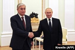 Russian President Vladimir Putin (right) greets Kazakh President Qasym-Zhomart Toqaev in Moscow on August 21, 2021.