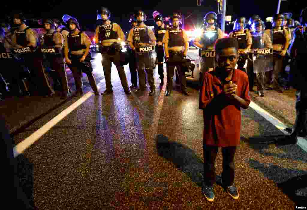 На фото - Амарион Аллен, 11-летний мальчик, который стоит перед полицейскими за неколько минут до того, как началась стрельба