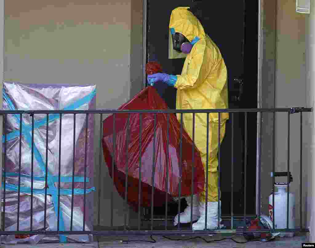 Работники&nbsp;в защитных костюмах убирают квартиру, в которой проживал&nbsp;человек с вирусом Эбола. Даллас, Штат Техас, США. 6 октября 2014 