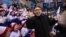 SOUTH KOREA -- A man impersonating North Korean leader Kim Jong Un gestures as he stands before North Korean cheerleaders attending the Unified Korean ice hockey game against Japan during the Pyeongchang 2018 Winter Olympic Games at the Kwandong Hockey Ce