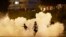 BELARUS -- Protesters run through smoke during a protest after the Belarusian presidential election in Minsk, August 9, 2020