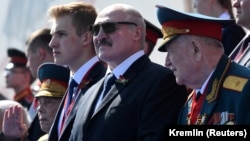 Президент Беларуси Александр Лукашенко (в центре) с младшим сыном Николаем на параде Победы в Москве. 24 июня 2020 года
