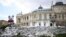 UKRAINE – People walk behind a sandbag barrier outside the Odesa National Academic Theatre of Opera and Ballet in Odesa, 22 June 2022