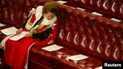 Баронесса Маргарет Тэтчер читает повестку заседания Палаты Лордов, ожидая речь королевы Елизаветы II, 13 ноября 2002 года