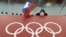 RUSSIA -- FILE - In this Feb. 18, 2014 file photo, a Russian skating fan holds the country's national flag over the Olympic rings at Adler Arena Skating Center during the 2014 Winter Olympics in Sochi, Russia.